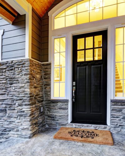 Front covered porch design boasts stone siding which creates immense curb appeal of luxurious home. Welcome mat lead to black front door accented with sidelights framed by white siding.
Northwest, USA